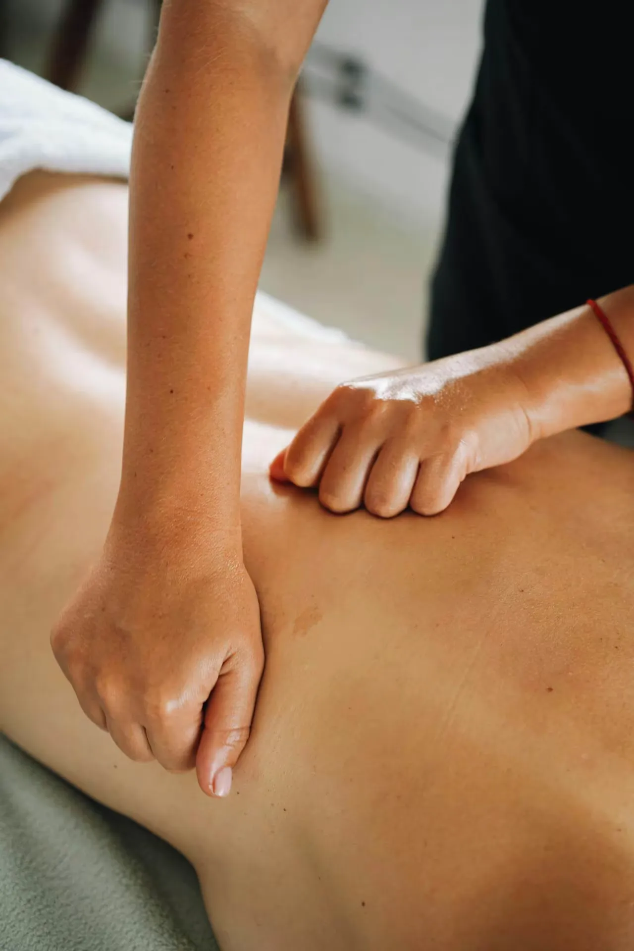 Massage therapist performing massage techniques on a client's back